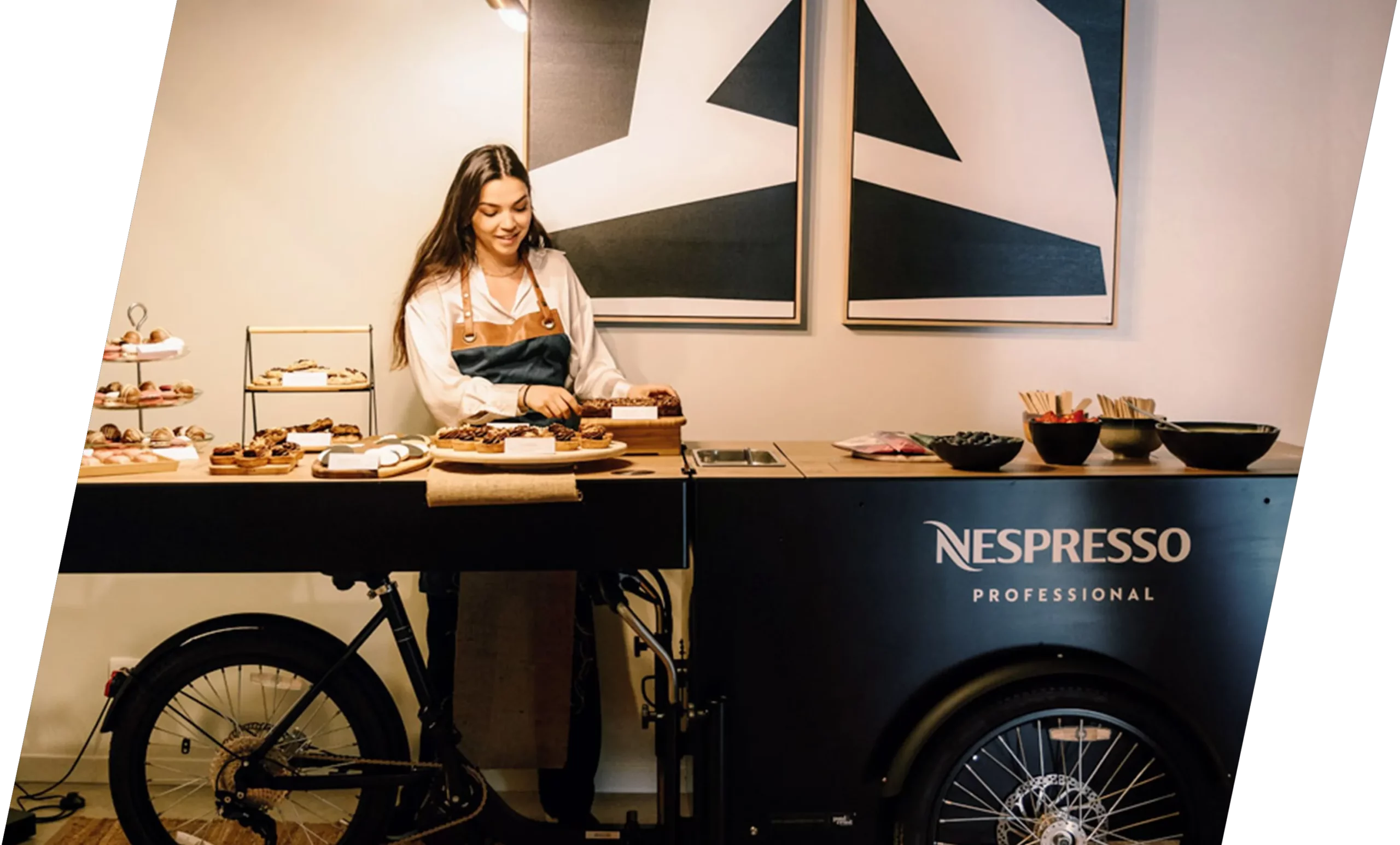 Eine Mitarbeiterin von Nespresso steht hinter dem Nespresso Bike von Paul&Ernst. Dieses vielseitige Bike wird von Nespresso für Promotion-Zwecke eingesetzt und dient als mobiles Highlight bei verschiedenen Events und Marketing-Aktivitäten.