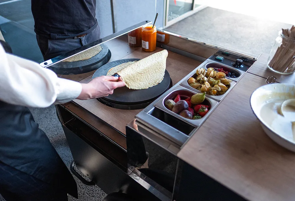 In diesem Fall wurde im Gastro Bike ein Crêpeeisen eingebaut, um köstliche Crêpes direkt vor Ort zuzubereiten. Das Gastro Bike kann jedoch flexibel mit verschiedenen Koch- oder Grillgeräten ausgestattet werden, sodass es sich perfekt an unterschiedliche kulinarische Konzepte anpasst. Ob für süße oder herzhafte Speisen – die Möglichkeiten sind nahezu unbegrenzt!